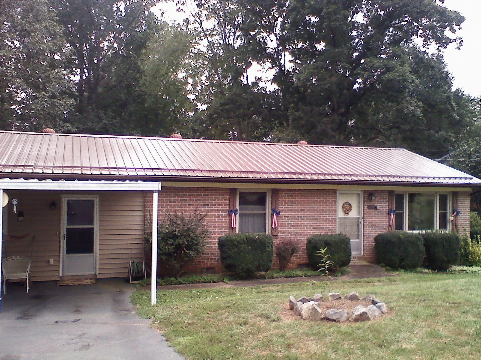 Bronze metal roof and carport on a brick ranch home — Roof Repair work by our crew in Webster